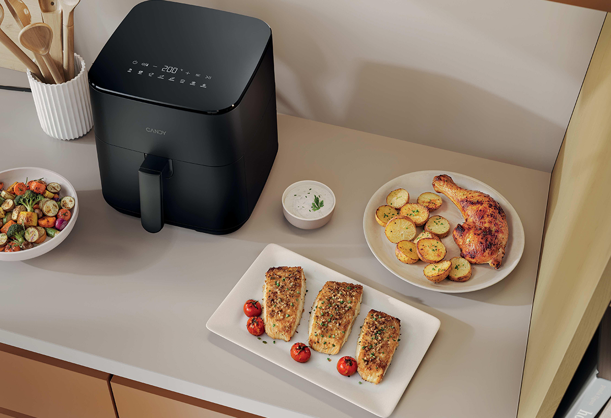 Η φριτέζα βρίσκεται τοποθετημένη πάνω σε έναν πάγκο μαζί με έτοιμα μαγειρεμένα, από αυτή, φαγητά.